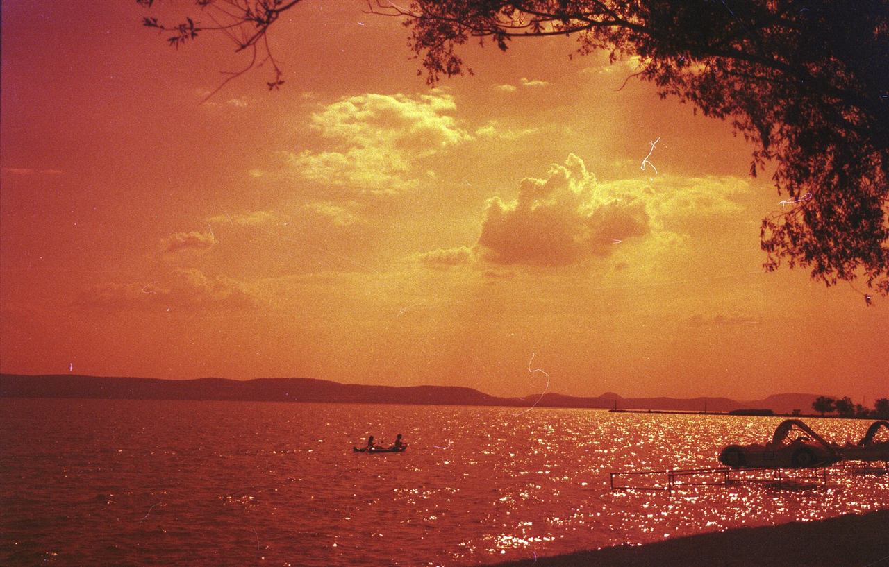 Wide view across the calm water of Lake Balaton toward the far shore